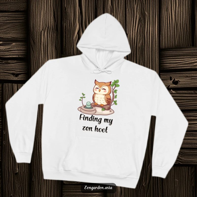 Funny owl character meditating peacefully in a serene Zen garden, featured on a comfy hoodie for ultimate relaxation.