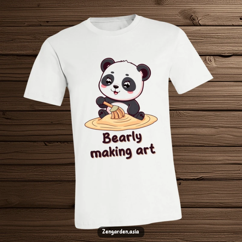 Funny playful panda character meticulously creating swirling sand art with a tiny rake on a t-shirt.